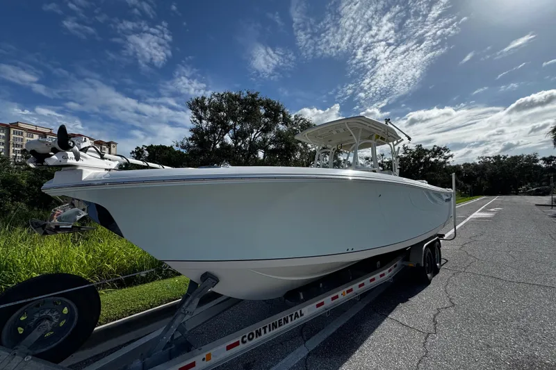 Slide: The Image of 2015 Sailfish 320 CC boat on trailer under a partly cloudy sky. - 4