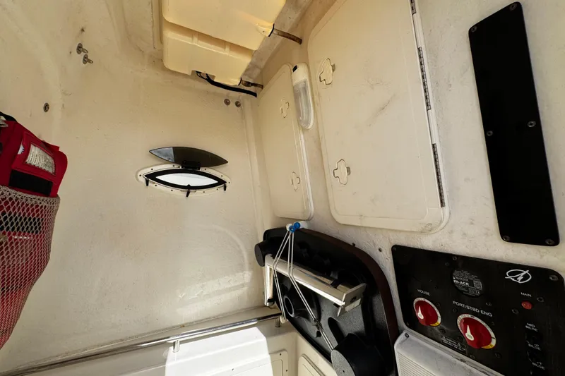 Slide: The Image of Interior of a 2015 Sailfish 320 CC boat, featuring storage compartments and control panel. - 44