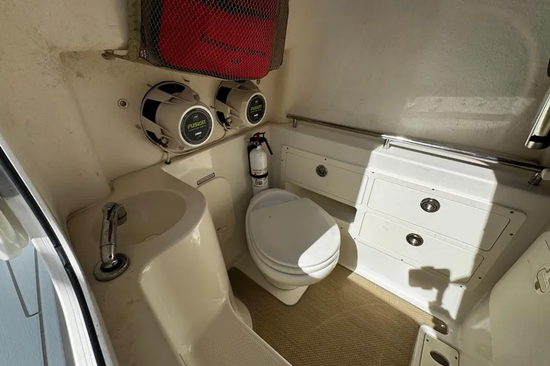Slide: The Image of 2015 Sailfish 320 CC boat interior with toilet, sink, speakers, and storage cabinets. - 45