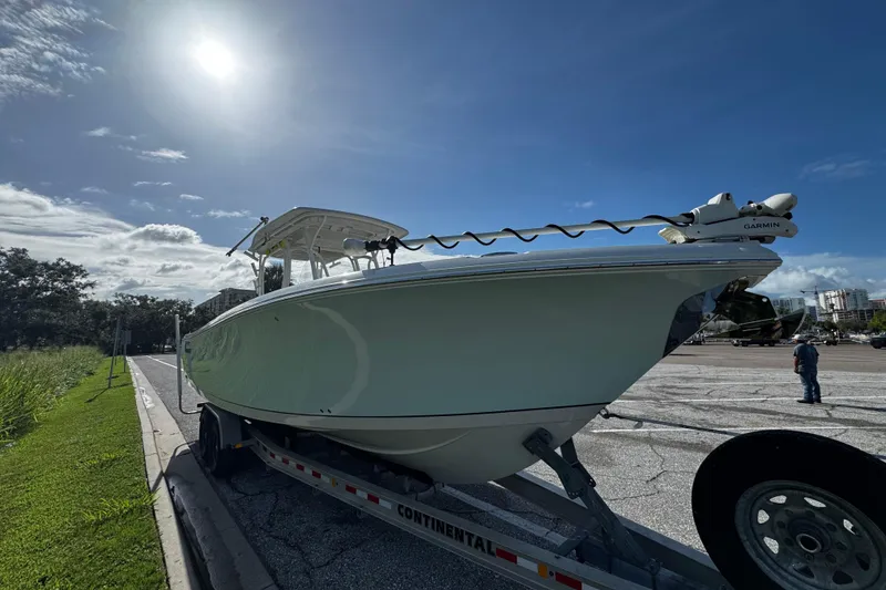 Slide: The Image of 2015 Sailfish 320 CC boat on trailer under bright sunlit sky. - 5