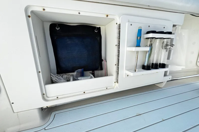 Slide: The Image of Storage compartment on a 2015 Sailfish 320 CC boat with organized tools and accessories. - 50
