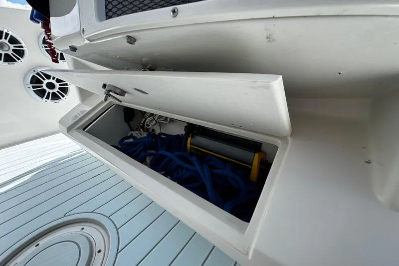 Slide: The Image of Open storage compartment on 2015 Sailfish 320 CC boat, containing blue ropes and equipment. - 53