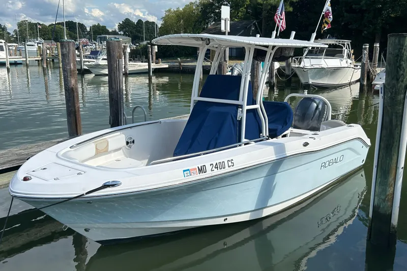Slide: The Image of 2016 Robalo R200 Center Console boat docked in a marina, calm water, clear sky. - 2