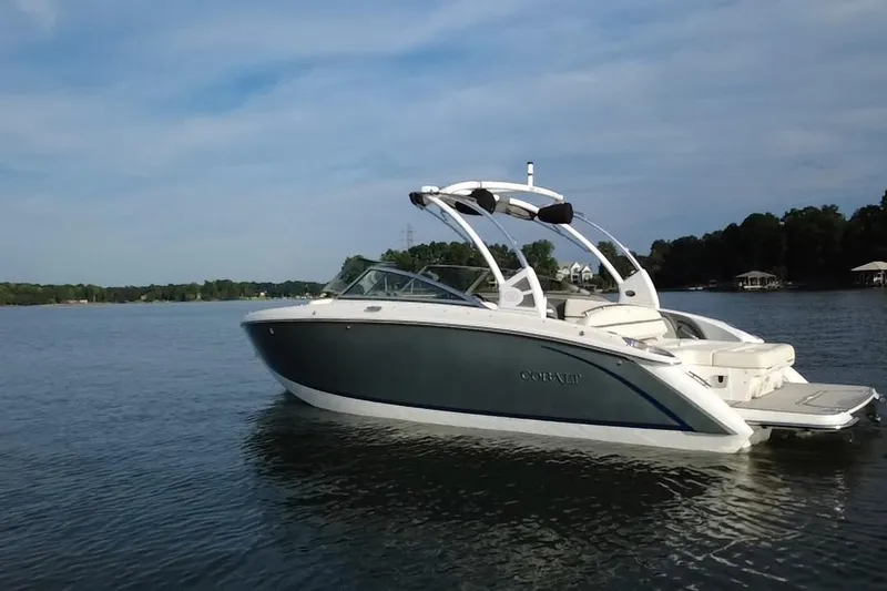 Slide: The Image of 2021 Cobalt R5 boat on a serene lake with a clear sky backdrop. - 16