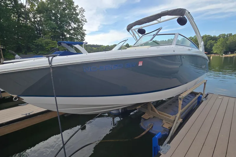 Slide: The Image of 2021 Cobalt R5 boat docked on a lift by a serene lake. - 2