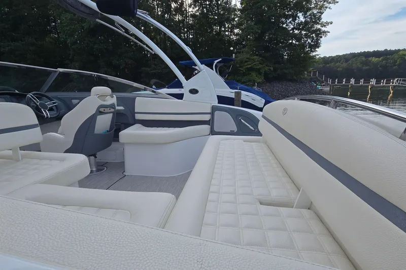 Slide: The Image of 2021 Cobalt R5 boat interior with luxurious seating, docked by a scenic lake. - 21