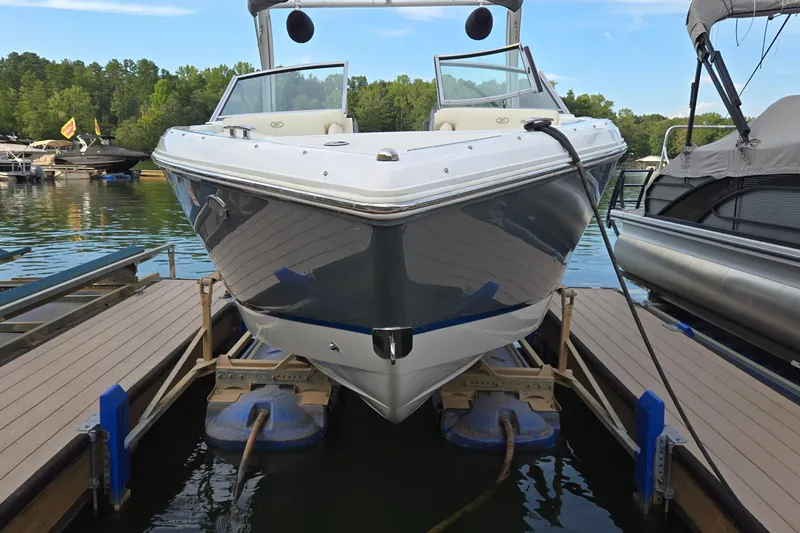 Slide: The Image of 2021 Cobalt R5 boat docked on a serene lake with lush green surroundings. - 4