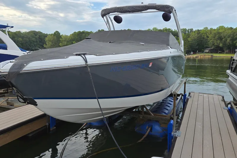 Slide: The Image of 2021 Cobalt R5 boat docked on a lift, covered, with scenic lake background. - 7