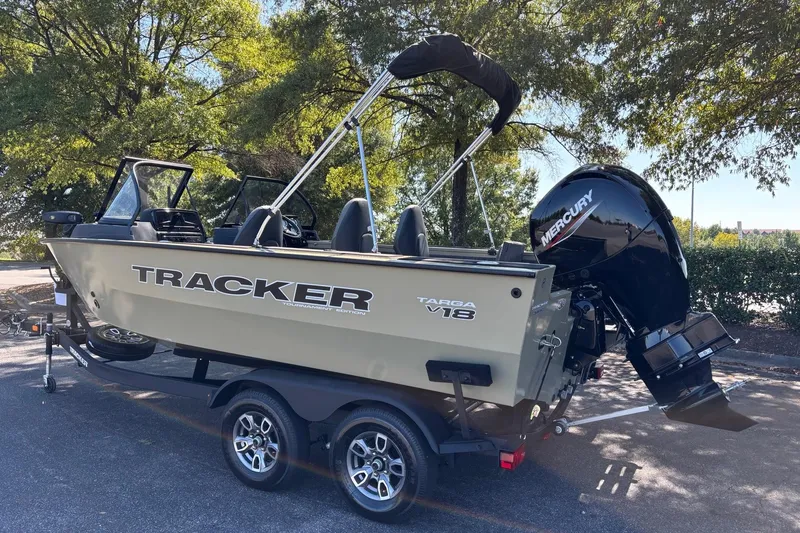Slide: The Image of 2026 Tracker Targa V-18 Combo boat on trailer, parked under trees. - 3
