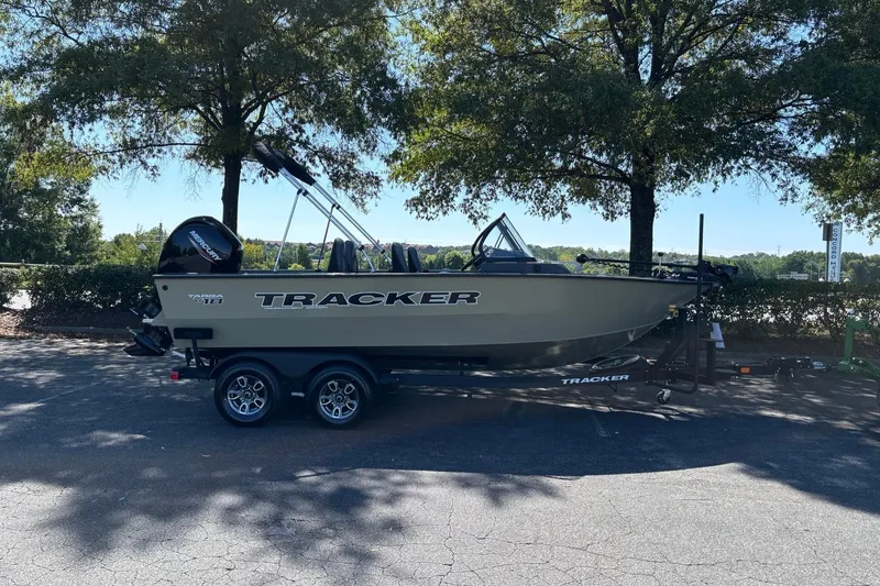 Slide: The Image of 2026 Tracker Targa V-18 Combo boat on trailer, parked under trees. - 4