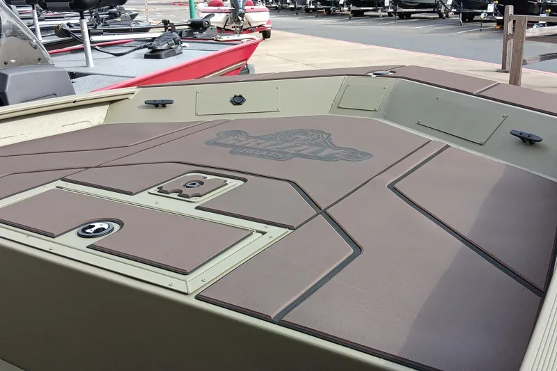 Slide: The Image of 2026 Tracker Grizzly 1860 CC boat deck with storage compartments and logo. - 2