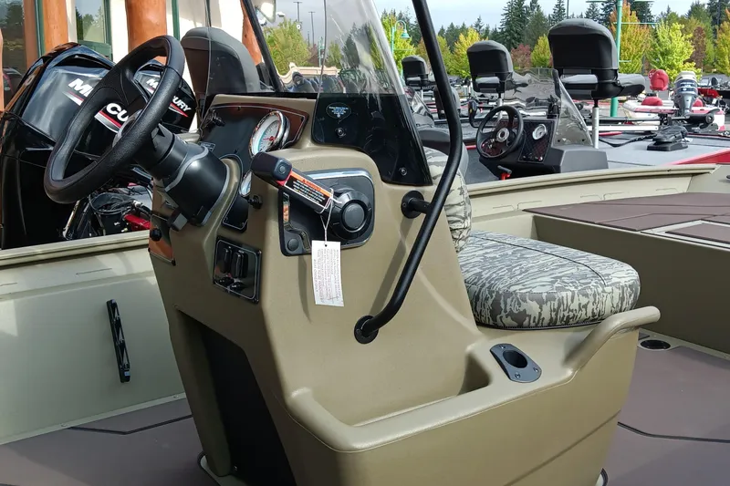 Slide: The Image of 2026 Tracker Grizzly 1860 CC boat interior with steering console and camo seat. - 4