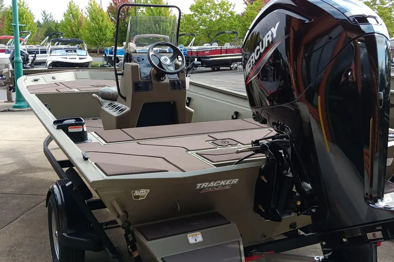 Slide: The Image of 2026 Tracker Grizzly 1860 CC boat with Mercury engine, displayed outdoors. - 5