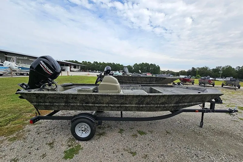 Slide: The Image of 2026 Tracker Grizzly 1648 SC boat on trailer, parked outdoors under cloudy sky. - 6