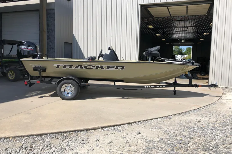 Slide: The Image of 2026 Tracker Pro Team 175 Crappie Edition boat parked outside a garage. - 7
