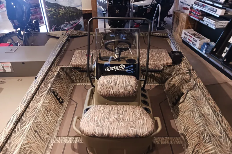 The Image of 2026 Tracker Grizzly 1860 CC boat interior with camouflage seating and steering console. - 0