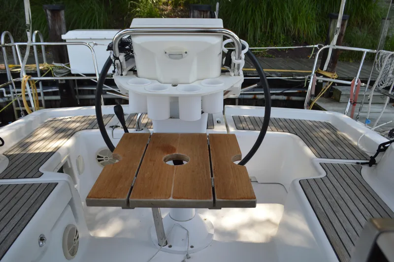 Slide: The Image of Cockpit of 2012 Beneteau Oceanis 34 sailboat with wooden table and steering wheel. - 12