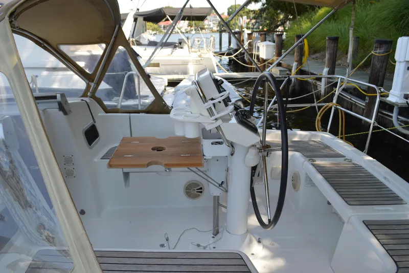 Slide: The Image of Cockpit of 2012 Beneteau Oceanis 34 sailboat with steering wheel and wooden table. - 13