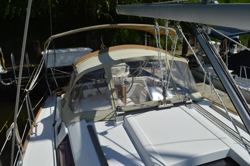 Slide: The Image of 2012 Beneteau Oceanis 34 sailboat with beige canopy docked at marina. - 15