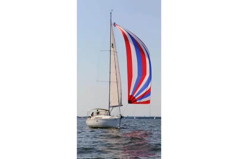 Slide: The Image of 2012 Beneteau Oceanis 34 sailboat with colorful spinnaker on open water. - 2