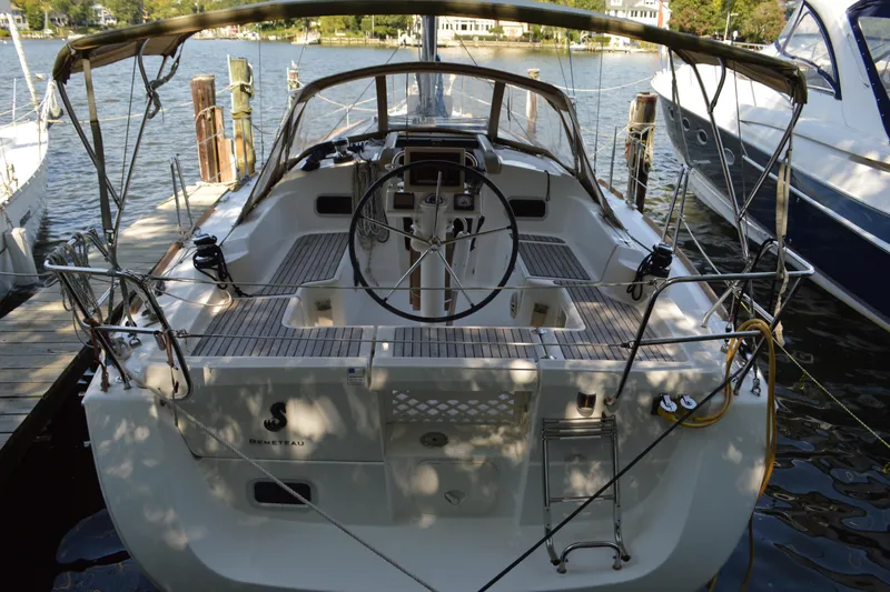 Slide: The Image of 2012 Beneteau Oceanis 34 sailboat docked, featuring spacious cockpit and steering wheel. - 20