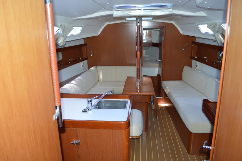 Slide: The Image of Interior of 2012 Beneteau Oceanis 34 sailboat with wood finish and cozy seating area. - 28