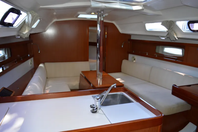 Slide: The Image of Interior of 2012 Beneteau Oceanis 34 sailboat with modern wood finish and seating area. - 29