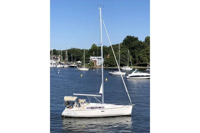 Slide: The Image of 2012 Beneteau Oceanis 34 sailboat on a calm river with other boats. - 3