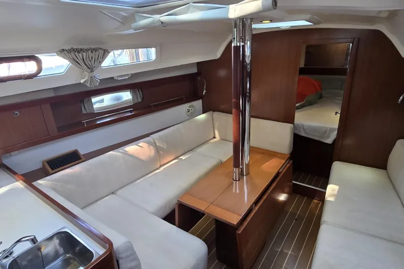 Slide: The Image of Interior of 2012 Beneteau Oceanis 34 sailboat with cozy seating and wooden finishes. - 31
