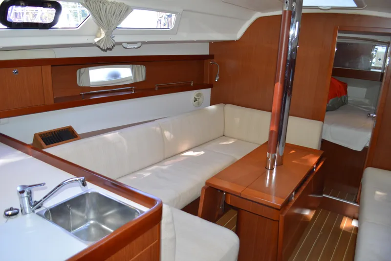 Slide: The Image of Interior of 2012 Beneteau Oceanis 34 sailboat with cozy seating and wooden finishes. - 32