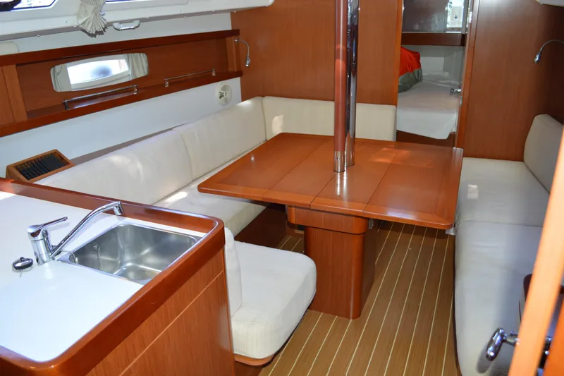 Slide: The Image of Interior of 2012 Beneteau Oceanis 34 sailboat with wood finish and cozy seating area. - 34