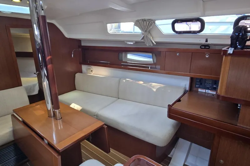 Slide: The Image of Interior of 2012 Beneteau Oceanis 34 sailboat with cozy seating and wooden finishes. - 36