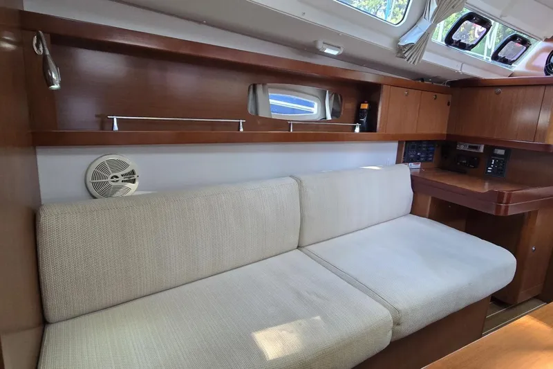 Slide: The Image of Interior of 2012 Beneteau Oceanis 34 yacht with beige sofa and wooden cabinetry. - 38