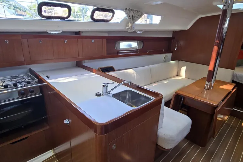 Slide: The Image of Interior of 2012 Beneteau Oceanis 34 sailboat with modern kitchen and cozy seating area. - 40