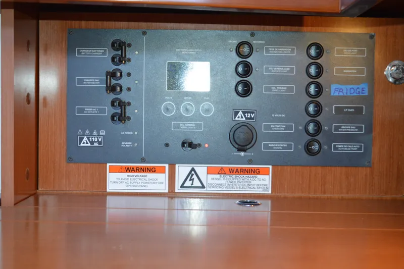 Slide: The Image of Electrical control panel on a 2012 Beneteau Oceanis 34 sailboat with warning labels. - 43