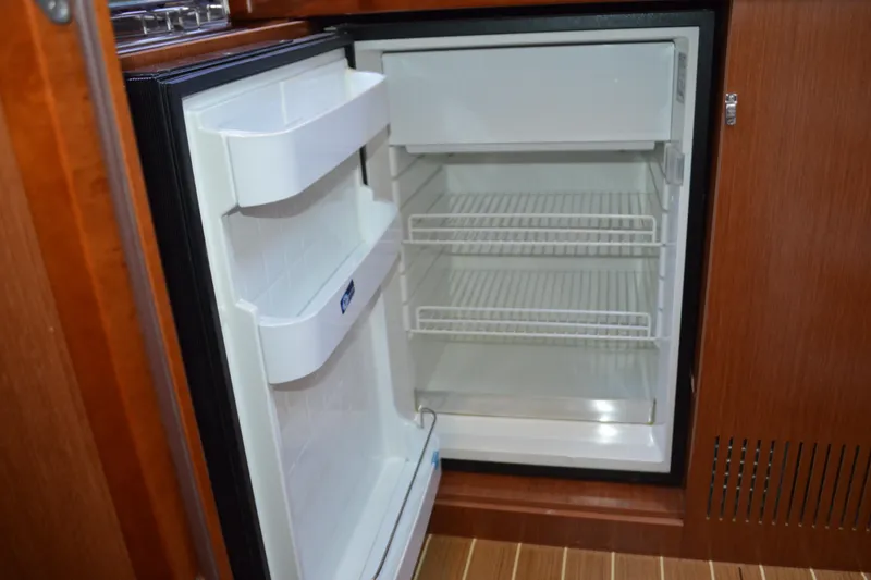 Slide: The Image of Open fridge inside 2012 Beneteau Oceanis 34 yacht, showcasing interior shelves. - 47