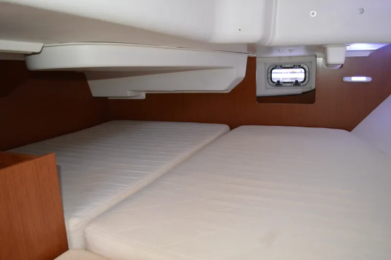 Slide: The Image of Interior cabin of 2012 Beneteau Oceanis 34 sailboat with twin beds and porthole. - 53