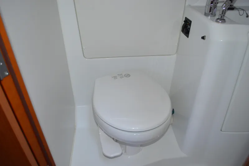 Slide: The Image of Beneteau Oceanis 34 (2012) yacht bathroom with compact white toilet. - 57