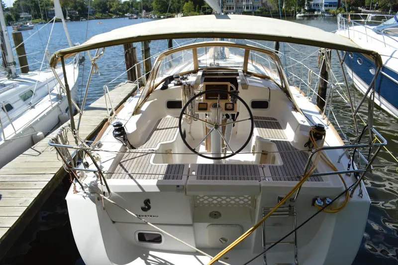 Slide: The Image of 2012 Beneteau Oceanis 34 sailboat docked, featuring spacious cockpit and steering wheel. - 6