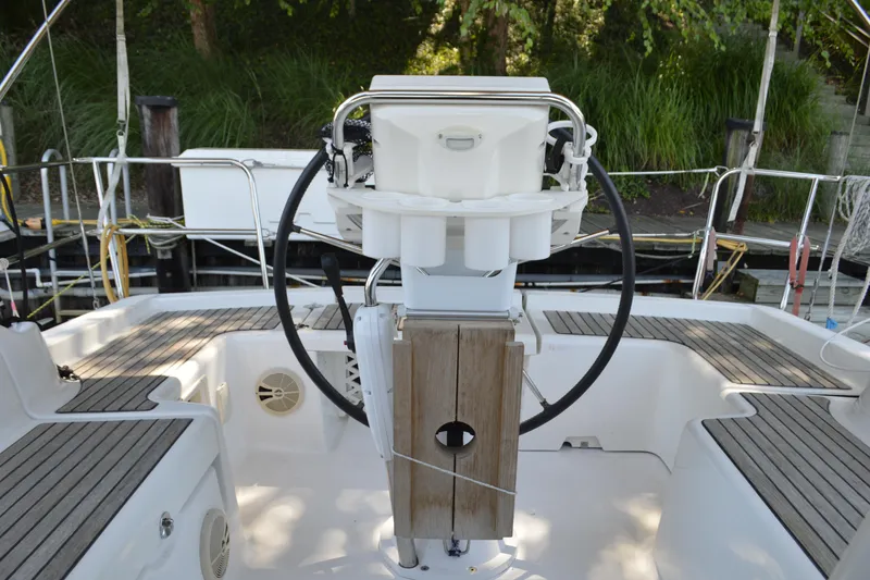 Slide: The Image of Cockpit of 2012 Beneteau Oceanis 34 sailboat with steering wheel and wooden flooring. - 8