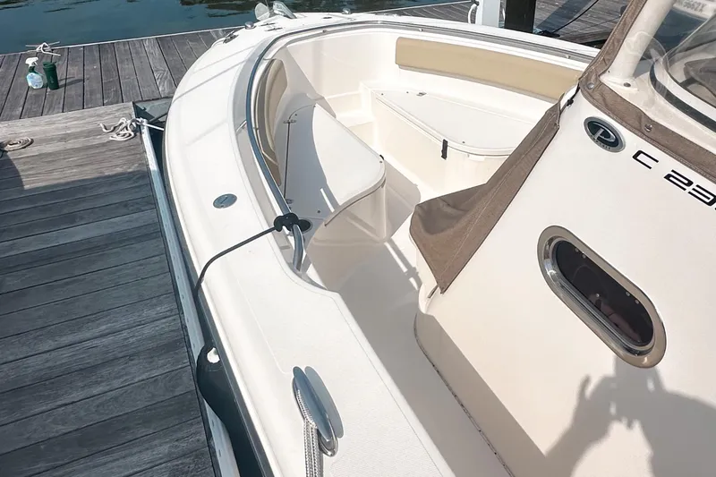 Slide: The Image of 2016 Pursuit C 238 Center Console boat docked, showcasing sleek design and spacious seating. - 2