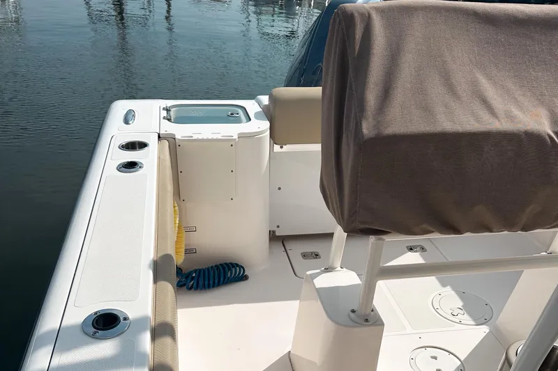 Slide: The Image of 2016 Pursuit C 238 Center Console boat interior with covered seating and fishing rod holders. - 3