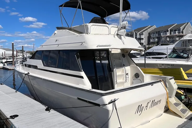 The Image of 1989 Mainship Mediterranean Convertible yacht docked at marina under clear blue sky. - 1
