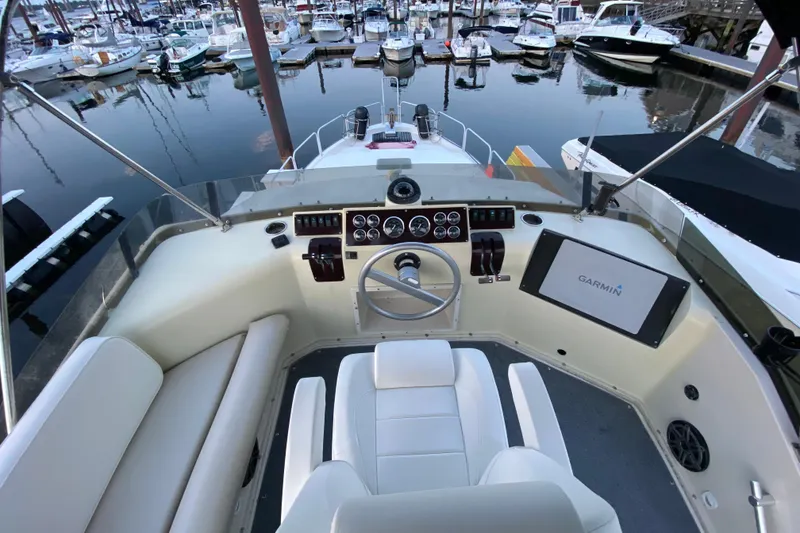 Slide: The Image of 1989 Mainship Mediterranean Convertible boat helm with Garmin navigation, docked in marina. - 12