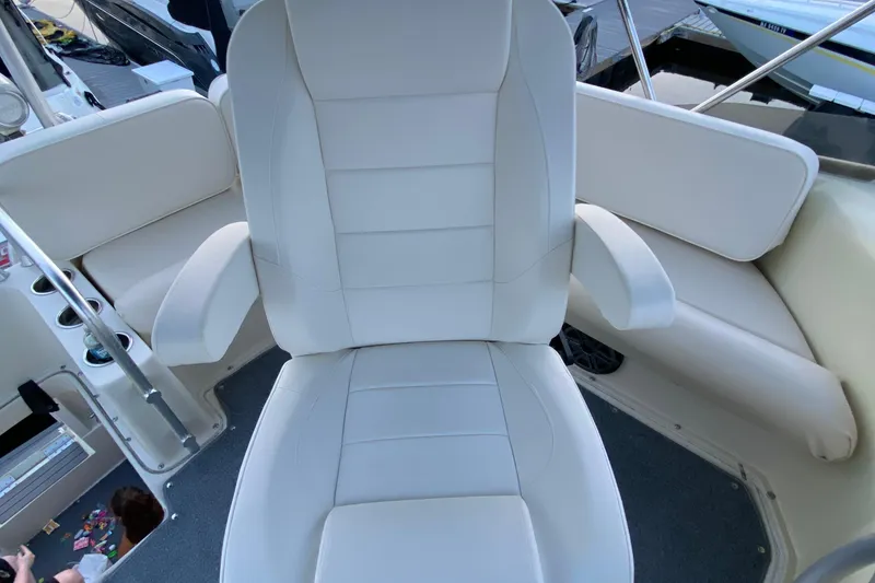 Slide: The Image of Captain's chair on 1989 Mainship Mediterranean Convertible boat, featuring white upholstery and armrests. - 16