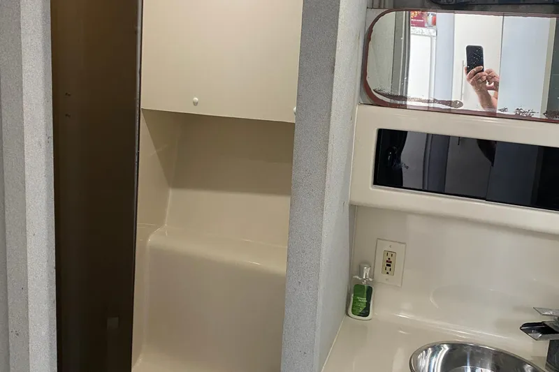 Slide: The Image of 1989 Mainship Mediterranean Convertible bathroom with sink, mirror, and storage cabinet. - 22
