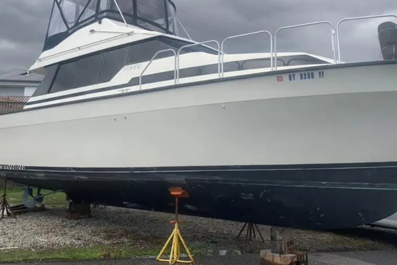 Slide: The Image of 1989 Mainship Mediterranean Convertible boat on stands, under cloudy skies. - 27