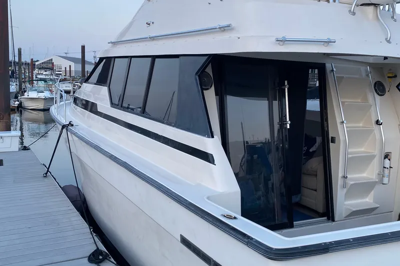 Slide: The Image of 1989 Mainship Mediterranean Convertible yacht docked at marina, showcasing sleek design and spacious interior. - 4