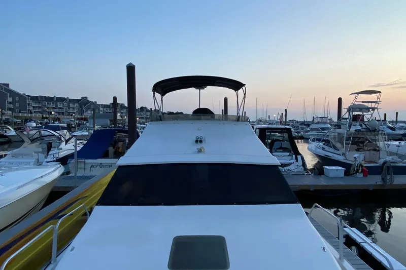 Slide: The Image of 1989 Mainship Mediterranean Convertible yacht docked at marina during sunset. - 7