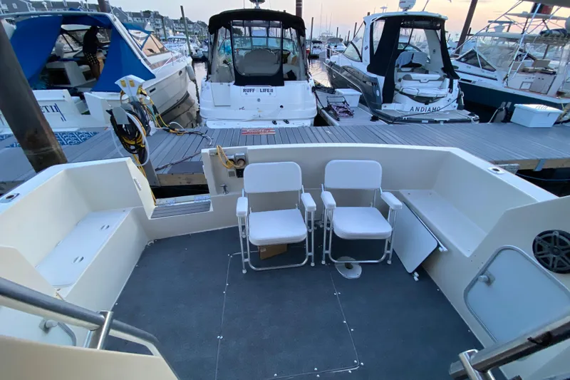 Slide: The Image of 1989 Mainship Mediterranean Convertible boat interior with seating, docked at marina. - 9